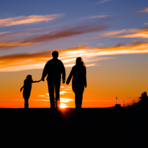 A colorful sunset silhouetting a family of three walking together holding hands.