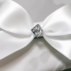 White ribbon bow with a large diamond ring in the center