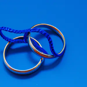 A pair of intertwined wedding rings in a bright blue background.