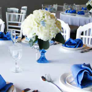 A wedding reception table with blue and white decor, including a bouquet of white flowers.