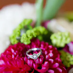 A wedding ring sitting atop a bouquet of flowers.